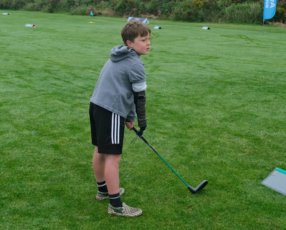 Boy with limb difference ‘excited’ to play golf with grandfather thanks to tool