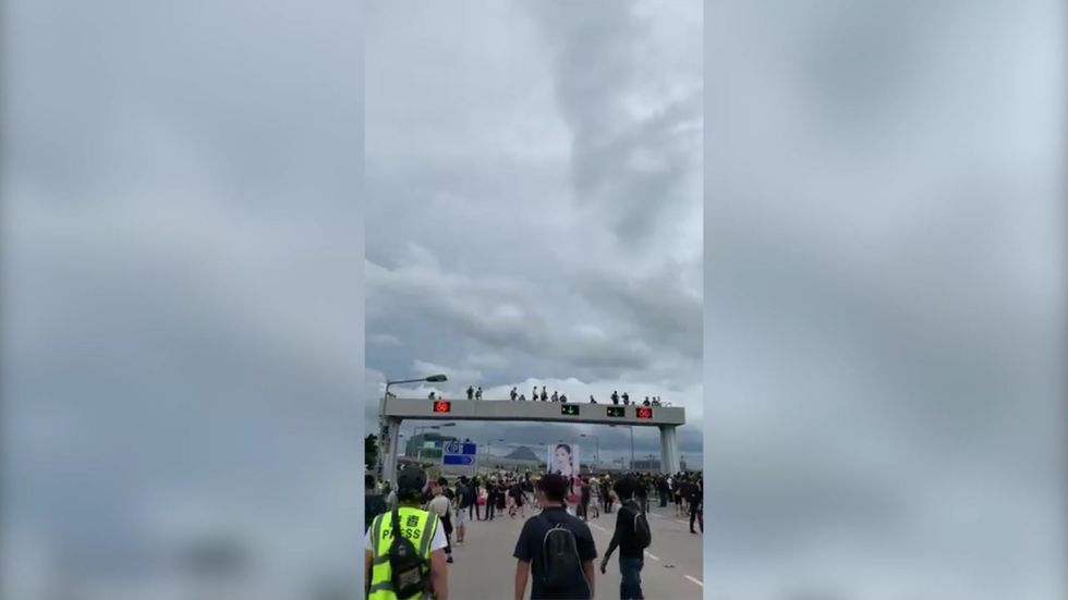 Protesters make their way between Hong Kong International Airport and Tung Chung after a day of violent clashes with police