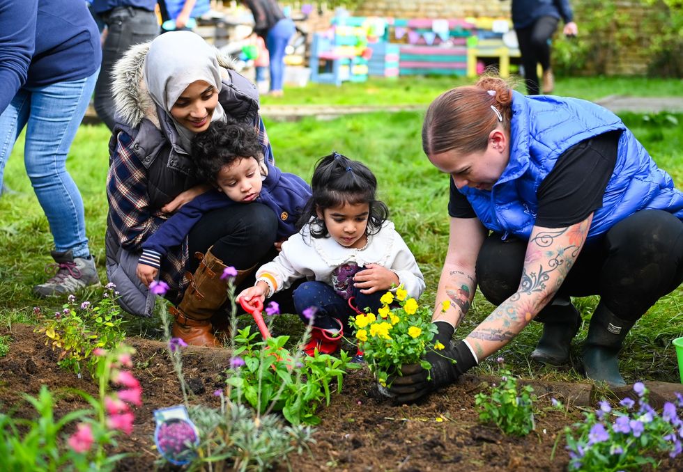 Lottery winners help spruce up garden for toddlers at charity farm