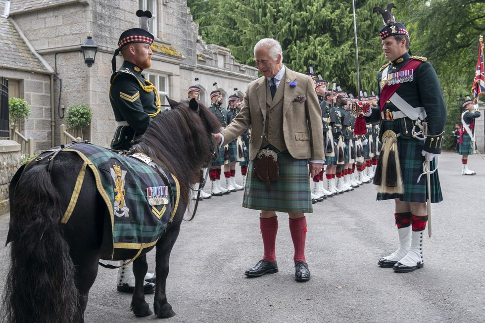 King pats Shetland pony mascot as a guard of honour marks his Balmoral arrival